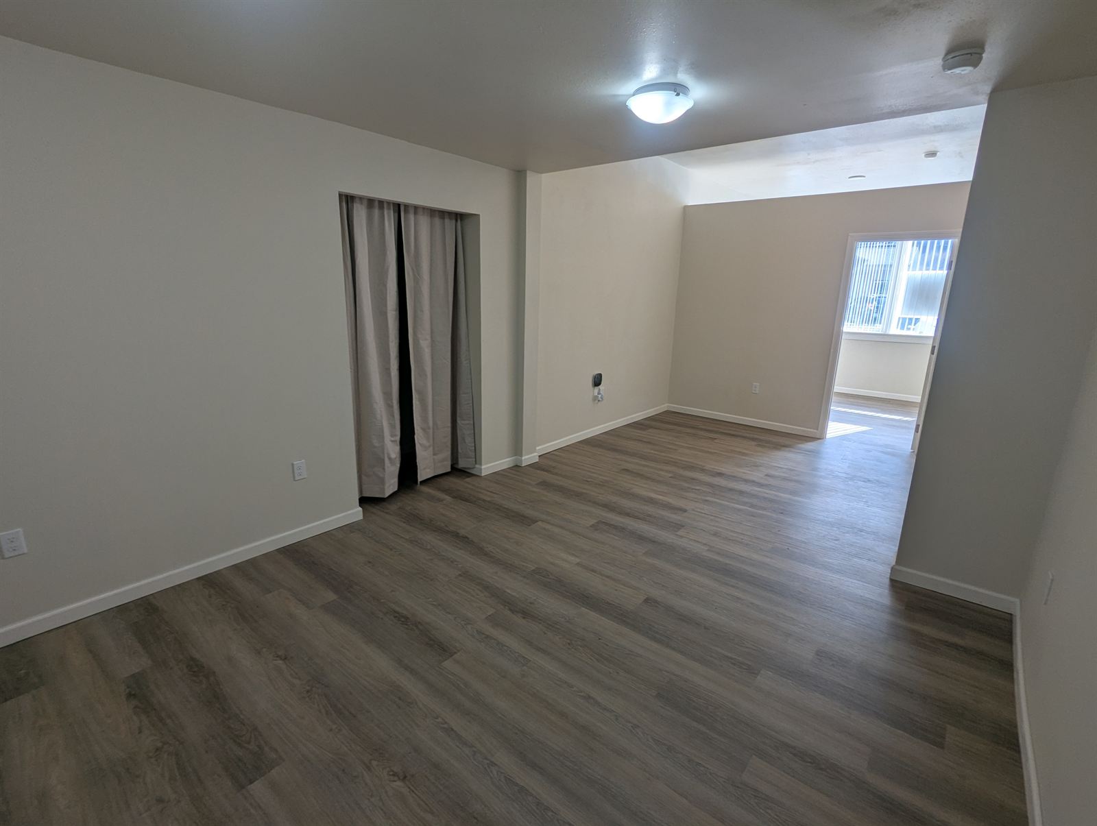 Spacious living room with a closet and large windows in Unit 2