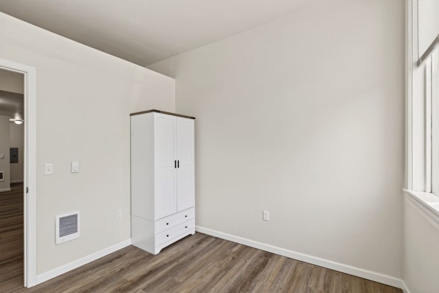 Unit 2 bedroom, unfurnished, with a built-in white wardrobe and a doorway to the hall