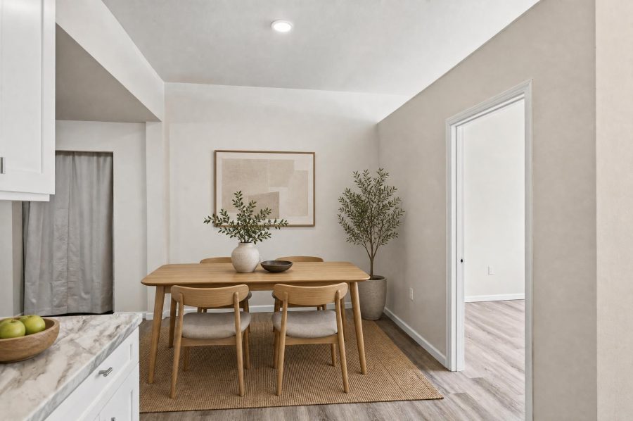Unit 2 dining area, virtually staged with a table and four chairs beside the kitchen counter