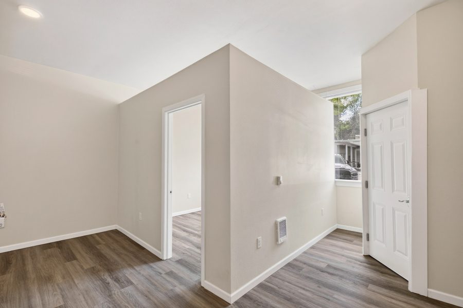 Unit 2 entry and hallway with the front door and a wall heater