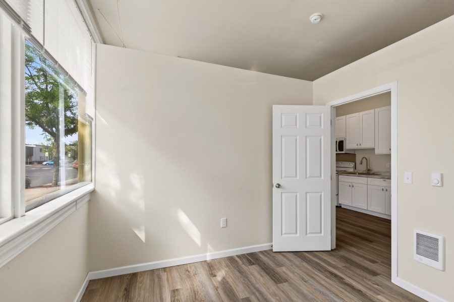 Unit 2 flex room with a large street-facing window and a door through to the kitchen