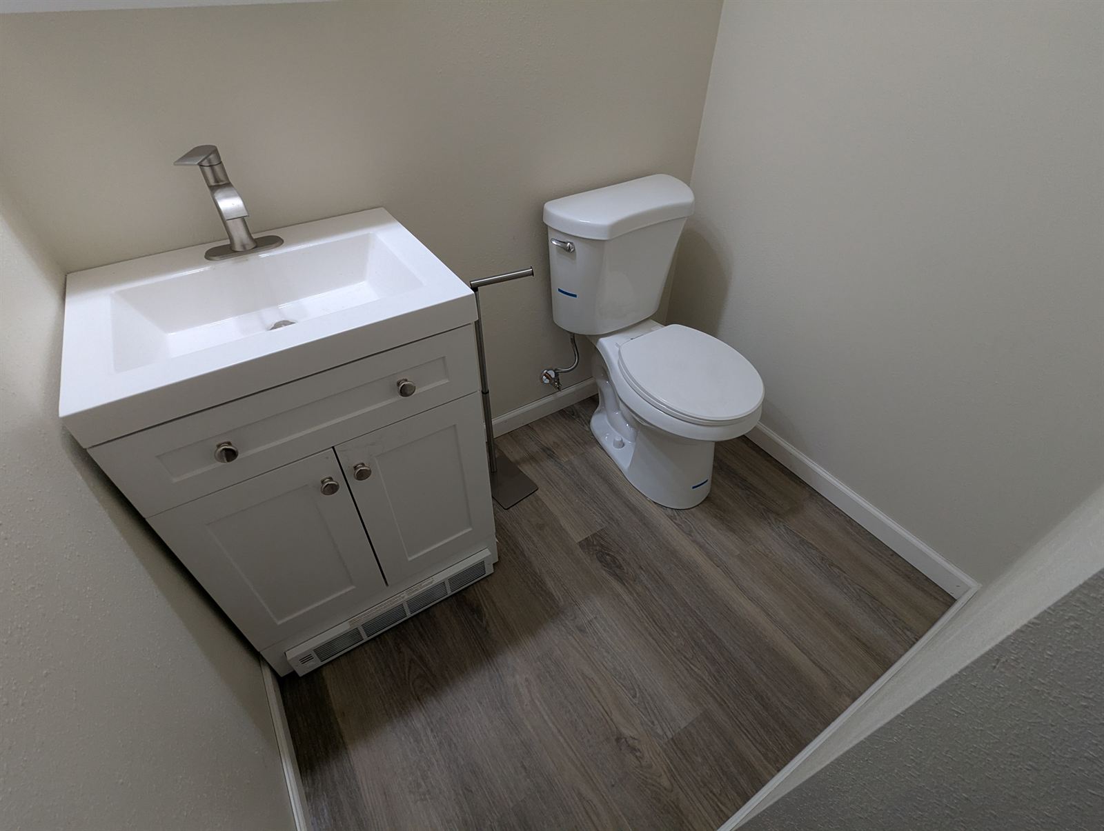 Updated bathroom with a white vanity sink and toilet in Unit 2