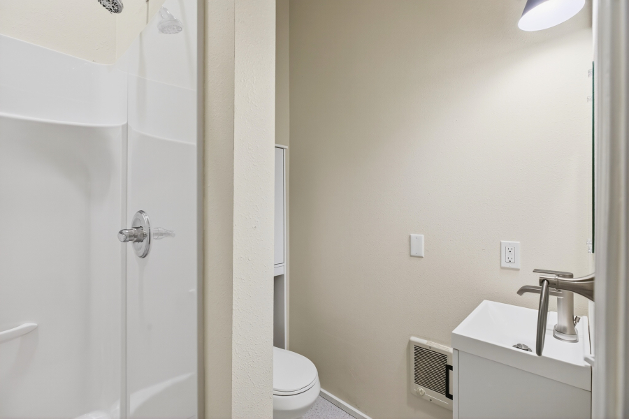 Unit 3 bathroom with a walk-in shower, toilet, and vanity