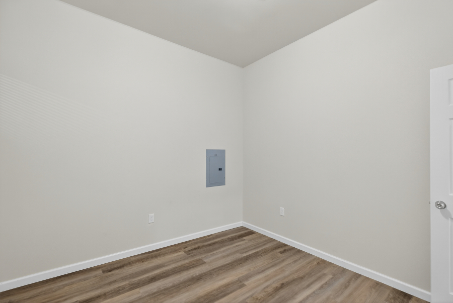 Unit 3 room with vinyl plank flooring and an electrical panel